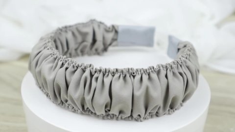 Gray color handmade scrunchy or scrunchies headband made out of cotton fabric texture. A hairband or headpiece with ruffle pattern.