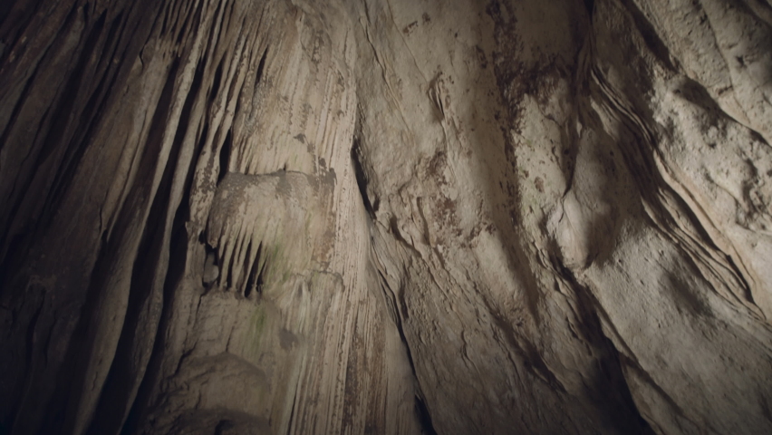Through an underground cave. Beautiful quiet cave with stalactites.