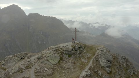 Drone shot of two hikers by a summit cross in Austria, Voralberg 03