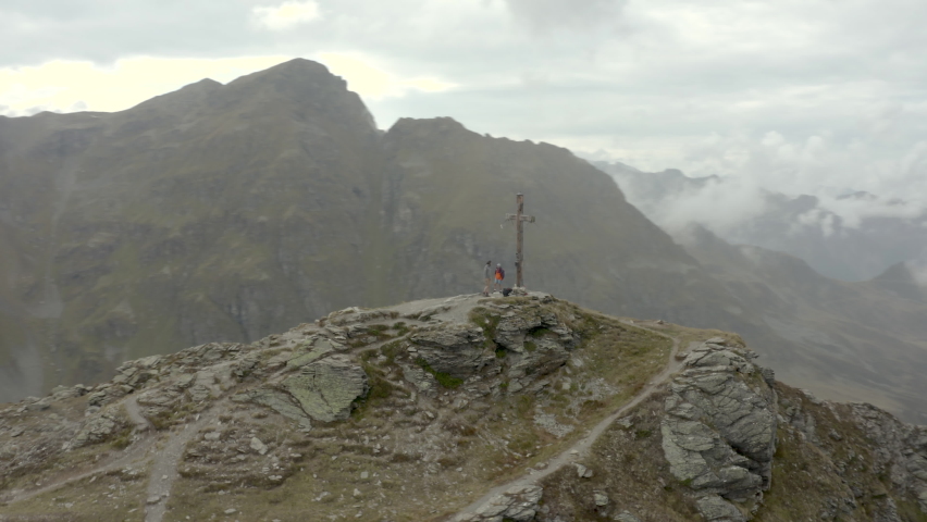 Drone shot of two hikers by a summit cross in Austria, Voralberg 06 Royalty-Free Stock Footage #1069263109
