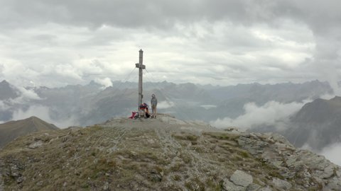 Drone shot of two hikers by a summit cross in Austria, Voralberg 02