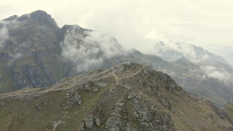 Drone shot of two hikers by a summit cross in Austria, Voralberg 09