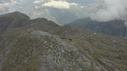 Drone shot of two hikers by a summit cross in Austria, Voralberg 