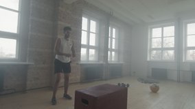 Slow-motion full shot of fit young african american sportsman training alone doing box jump exercise in smoky loft style studio - Powered by Shutterstock - Get 15% off with code: PIKWIZARD15