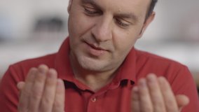 Young Muslim man at home with open palms praying to God. Praying man.Slow motion video.Close up.Close up.