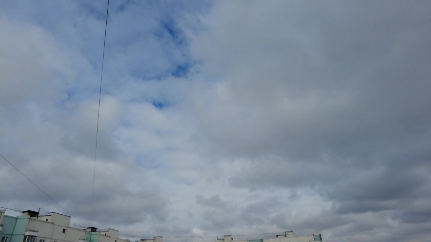Time lapse of floating clouds over panel old multistoried houses