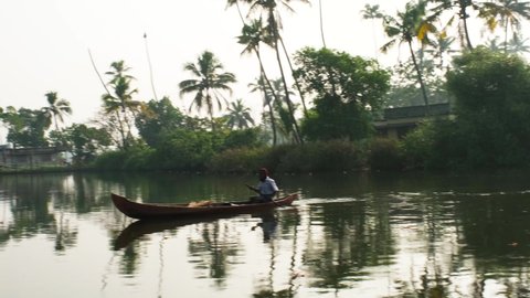 Cochin, Kerala India February- 19-2021: A person rowing the traditional canoe during morning light in the backwaters of Kochi, Kerala.  