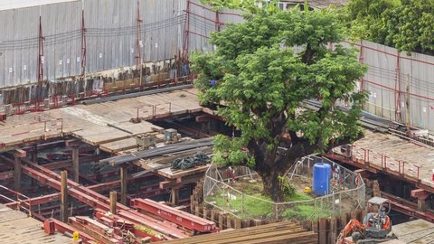 Bangkok, Thailand - November 21, 2020: Footage 4k Timelapse, Overhead view of construction on a suspended platform at the construction site, Preserve big trees in the project area.