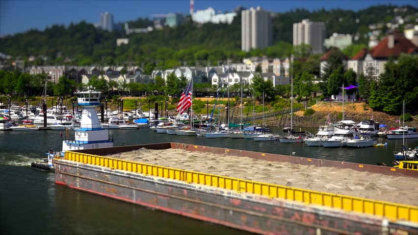 A tugboat pushes a barge of sand down the Willamette River in Portland, Oregon