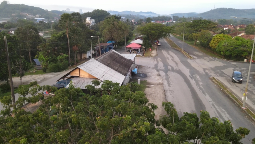 Drone flying above restaurant and flying towards other shops in desa  pinggiran putra.