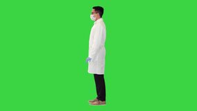 Wide shot. Side view. Doctor holding Covid-19 vaccine in hand and nodding on a Green Screen, Chroma Key. Professional shot in 4K resolution. 070. You can use it e.g. in your medical, commercial video