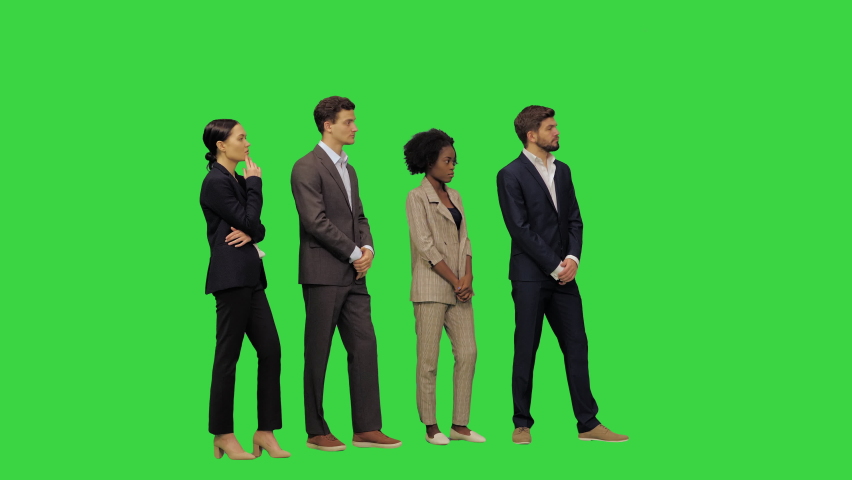 Wide shot. Front view. People standing in a line A cautious young man in business clothes offers his female colleague to switch positions, as he is taller and she cannot see a thing on a Green Screen | Shutterstock HD Video #1069300165
