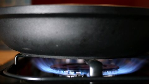 Process of burning and appearing blue flame of gas methane or propane on kitchen gas stove. Kitchen burner switching. Natural gas inflammation. Selective focus. Close-up.