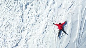 The girl on a snow angel shows, video 4K, aerial view