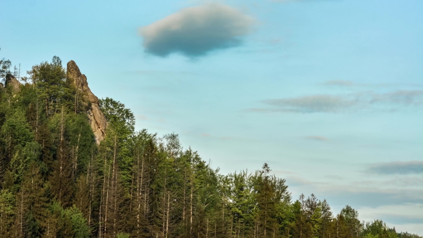 time lapse of clouds moving over woody hills