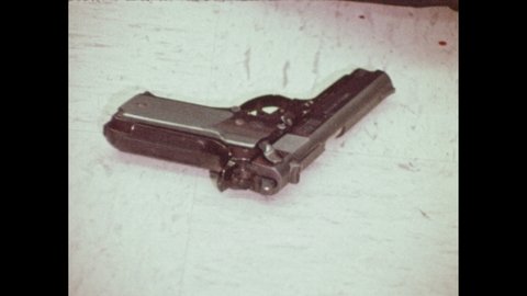1970s: A semi-automatic gun on a linoleum floor. A crusty old revolver, the chamber spins and reveals damage.