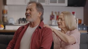 The old woman rubs her husband's aching back and shoulders. His wife rubs the shoulders and back of the bearded old man who has a lot of pain. Massage concept.Close up. - Powered by Shutterstock - Get 15% off with code: PIKWIZARD15