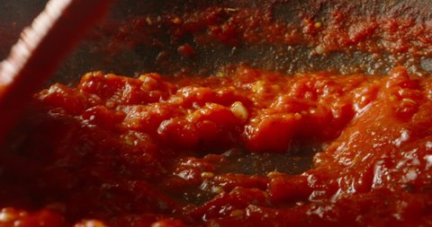 Italian tomato sauce is boiling and stirring in a pan for pizza or pasta, 4k footage