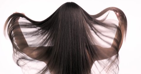 Woman moves long hair. Rear view. Girl shakes long straight hair. Slow motion footage. Rear view. 4k. Female model is fluttering hair. 