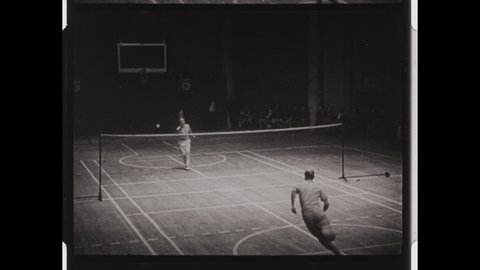 1950s Los Angeles, CA. Two Men play Badminton on an indoor Court. Man Scores a point by hitting Shuttlecock. 4K Overscan of Vintage Archival 16mm Film Print