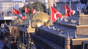 The red Turkish flag flies in the wind against the backdrop of the Bosporus and views of Istanbul