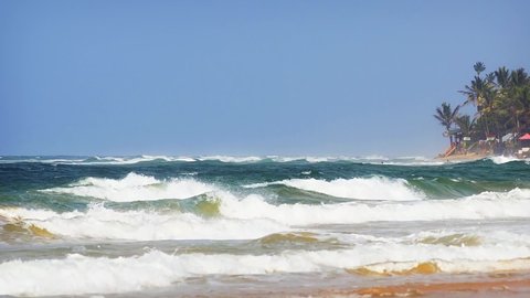 Row after row of choppy waves. driven by strong. seasonal winds. roll onto a tropical beach at Hikkaduwa Sri Lanka