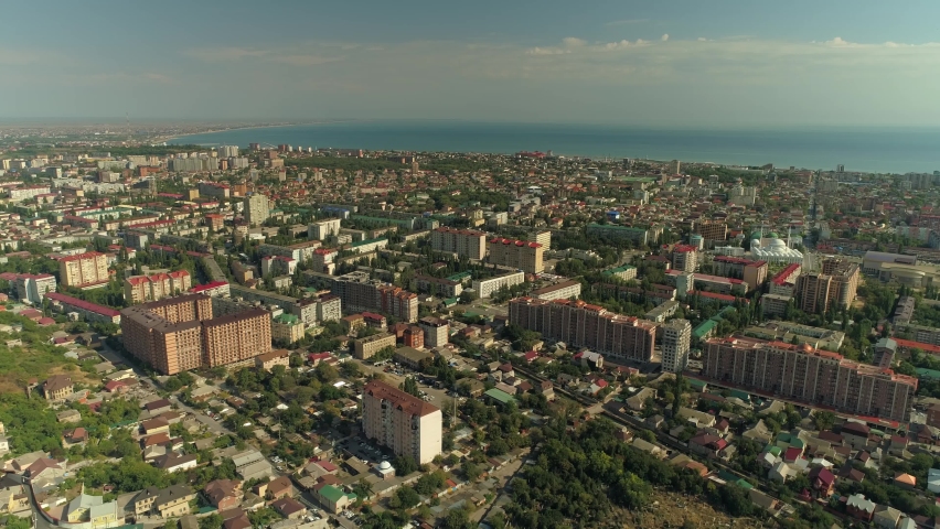 From great height summer city center Makhachkala Dagestan cityscape. Blue sky clouds Beautiful downtown. Caspian sea horizon. Modern and old street houses. Road traffic. Russia Caucasus travel tourism Royalty-Free Stock Footage #1069332688