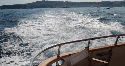 Slow motion of the foamy path from the yacht, the boat goes by sea, raging stream of sea water from under the ship at sunset, high speed, luxury life, a clear sunny weather, the Ligurian Sea, nobody