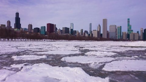 Urban Skyline of Chicago Loop and Frozen Lake Michigan with Ice Blocks on Winter Frosty Day. Aerial View. United States of America. Drone Flies Forward. Low Level Shot