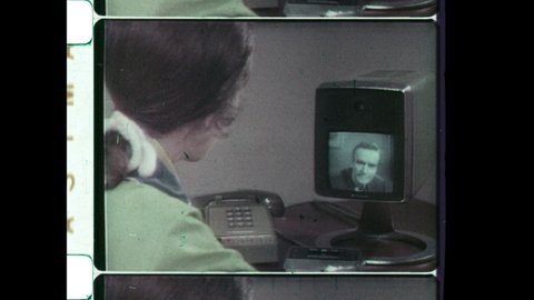 1970s Chicago, IL. Man calls Secretary on Bell Labs Picturephone, an early videotelephony concept similar to Facetime, Skype or Zoom. 4K Overscan of Vintage Archival 16mm Film Print. 