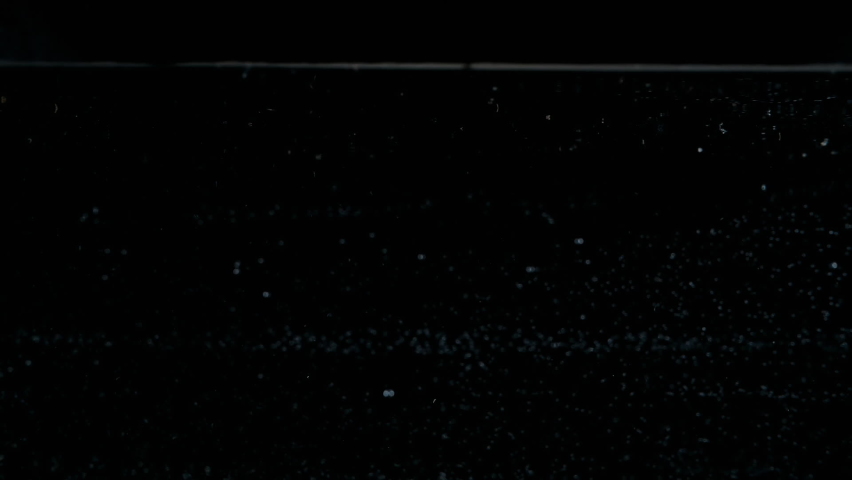 Red juicy strawberries dropped falling in water with lot of splashes, bubbles and drops on black background closeup