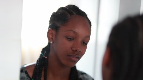 African black adolescent teenage girl standing in front of mirror