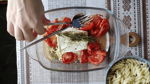 Italian dish of  pasta mixing with Feta cheese baked and tomatoes on a dark background. Fetapasta. Trending viral recipe, Flat lay, copy space
