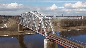 Metal railway train bridge over the river
Belarus Orsha Dnieper River. 
early spring Aerial footage from drone straight backward landscape revealing panorama