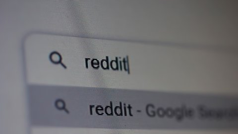 Buenos Aires, Argentina - March 2021: Searching for "Reddit" in an Internet Search Engine on a Computer. Close Up. 4K Resolution.