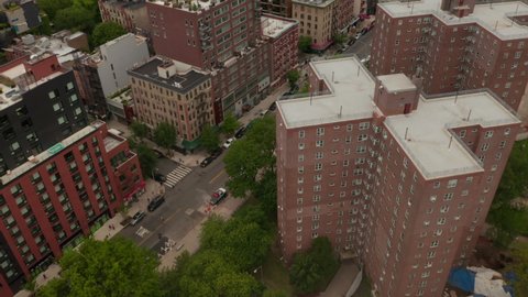 Aerial tilting dolly shot of residential neighborhoods of Alphabet City and East Village with New York City skyscrapers in the background
