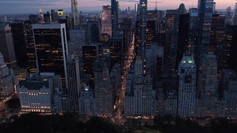 Manhattan Skyline at night with flashing City lights in New York City over Central Park, Aerial forward dolly in
