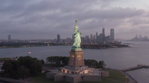 Manhattan, New York City Skyline revealing in front of Statue of Liberty, early morning Sunrise Aerial View