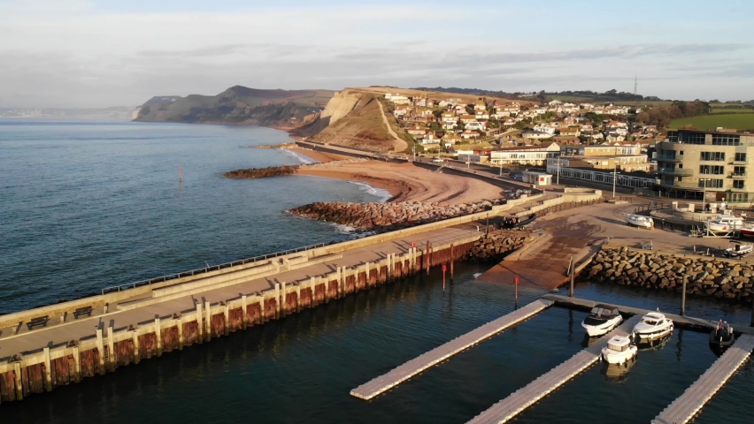 Downwards pedestal aerial shot looking towards the cliffs and the harbour of West Bay Dorset England UK