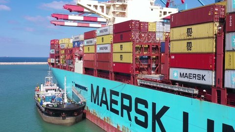 Haifa, Israel - November 1, 2020: Bunkering operation at port, Small fuel tanker loading a Maersk mega Container Ship with fuel, Aerial view.