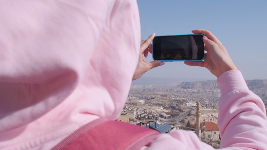 Girl Taking Pictures on Phone. View from behind Shoulder. Vacation. Elevation. Hill. Nice View of Ancient City. Tourism. Travel to Eastern Country. Culture. Ancient Walls. Photo for Memory. History