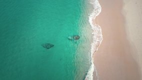 Sea wave and beautiful sand beach aerial view drone flying shot. Aerial top view of ocean blue wave break on a Surin beach, Phuket Thailand. Footage 4k B-roll