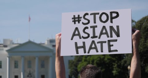 WASHINGTON, DC - Circa June, 2020 - A man waves a handmade STOP ASIAN HATE hashtag protest sign outside the White House.	
