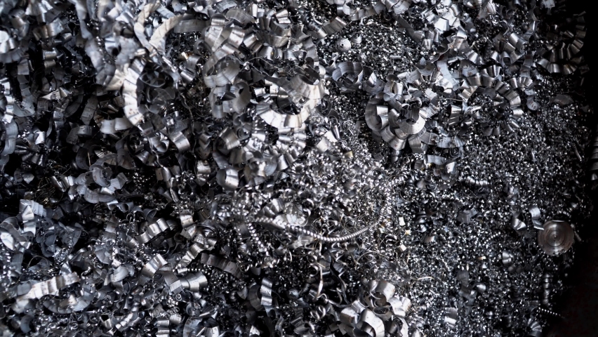 Steel scrap materials recycling. Aluminum chip waste after machining metal parts on a cnc lathe. Closeup twisted spiral steel shavings. Small roughness sharpness, possible granularity, blurred focus
 Royalty-Free Stock Footage #1069405888