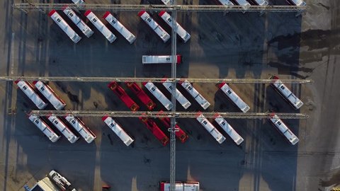 TTC public transit buses at large operations, maintenance and storage facility top down as bus drives through parking lot; aerial
