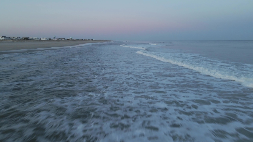 Frothy Ocean Waves Washing Up On Sandy Shore During Sunset At Long Beach Island In New Jersey, USA. - Low Aerial Shot