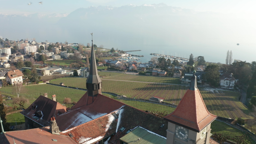 Flying past church tower overlooking green field