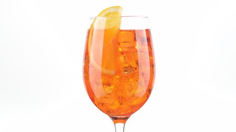 Aperol Spritz Cocktail with ice isolated on white background, rotation. glass of Summer orange cocktail