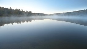 Wide angle view of Spruce Knob Lake in Appalachian mountains of Canaan valley in West Virginia with sunrise morning mist fog floating above water in Monongahela National Forest in autumn fall season - Powered by Shutterstock - Get 15% off with code: PIKWIZARD15