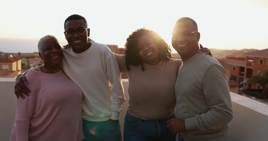 Happy african family looking and smiling in camera on patio outdoor at sunset | Shutterstock HD Video #1069437547